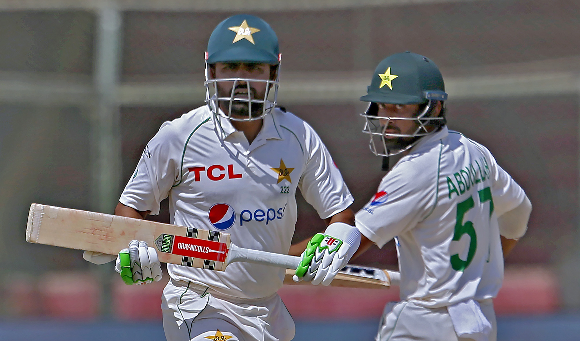 Pakistan's Babar Azam, left, and Abdullah Shafique run between the wickets during the fourth day of the second test match against Australia at the National Stadium in Karachi Pakistan, on March 15, 2022. (AP)