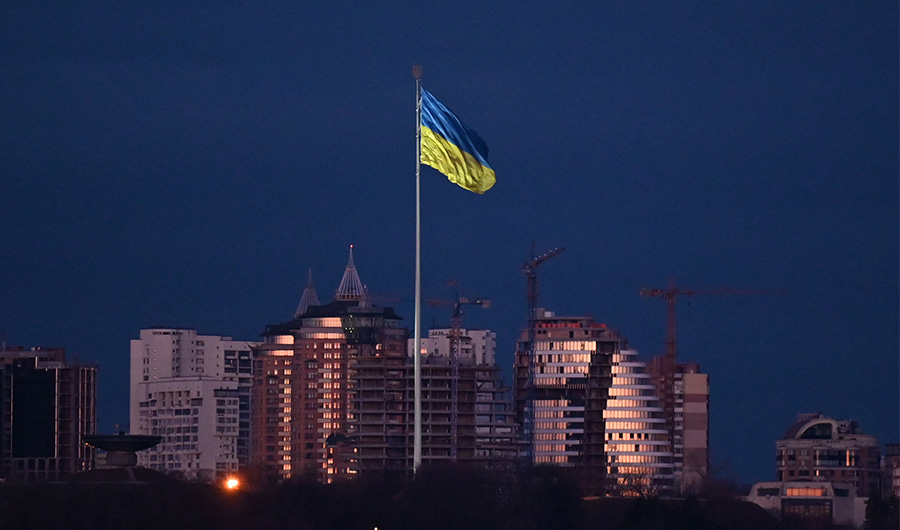 Ukraine's biggest national flag flies in Kyiv before dawn on March 16, 2022. (AFP)