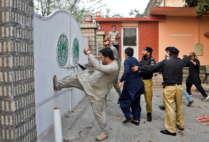 Police officers try to stop the supporters of the ruling political party Pakistan Tehreek-e-Insaf, as they stormed in protesting at the entrance of the Sindh House in Islamabad, Pakistan March 18, 2022. (REUTERS)