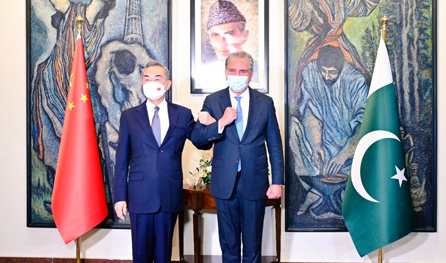 Chinese State Councilor and Foreign Minister Wang Yi (L) poses for a photo with Pakistan's Foreign Minister Shah Mahmood Qureshi (R) in Islamabad on March 22, 2022. (Foreign Office)