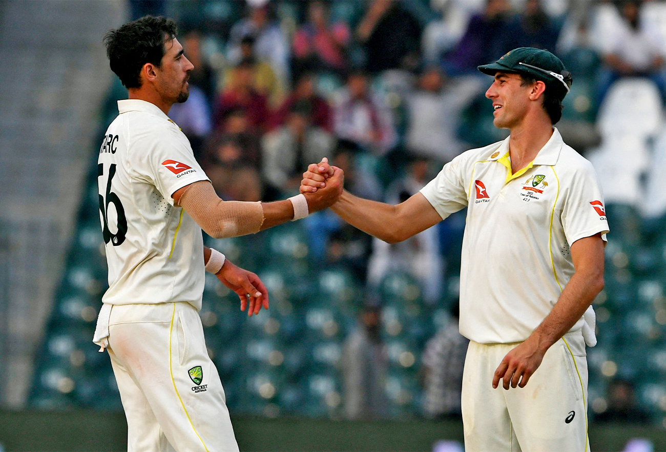 Australia's Mitchell Starc (L) celebrates with captain Pat Cummins after taking the wicket of Pakistan's Naseem Shah (not pictured) during the third day of the third cricket Test match between Pakistan and Australia in Lahore on March 23, 2022. (AP)