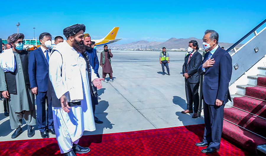 This handout photo released by the Taliban Foreign Ministry shows Taliban Foreign Minister Amir Khan Muttaqi (L) greeting China's Foreign Minister Wang Yi (R) upon his arrival at the Kabul airport in Kabul on March 24, 2022. (AFP)