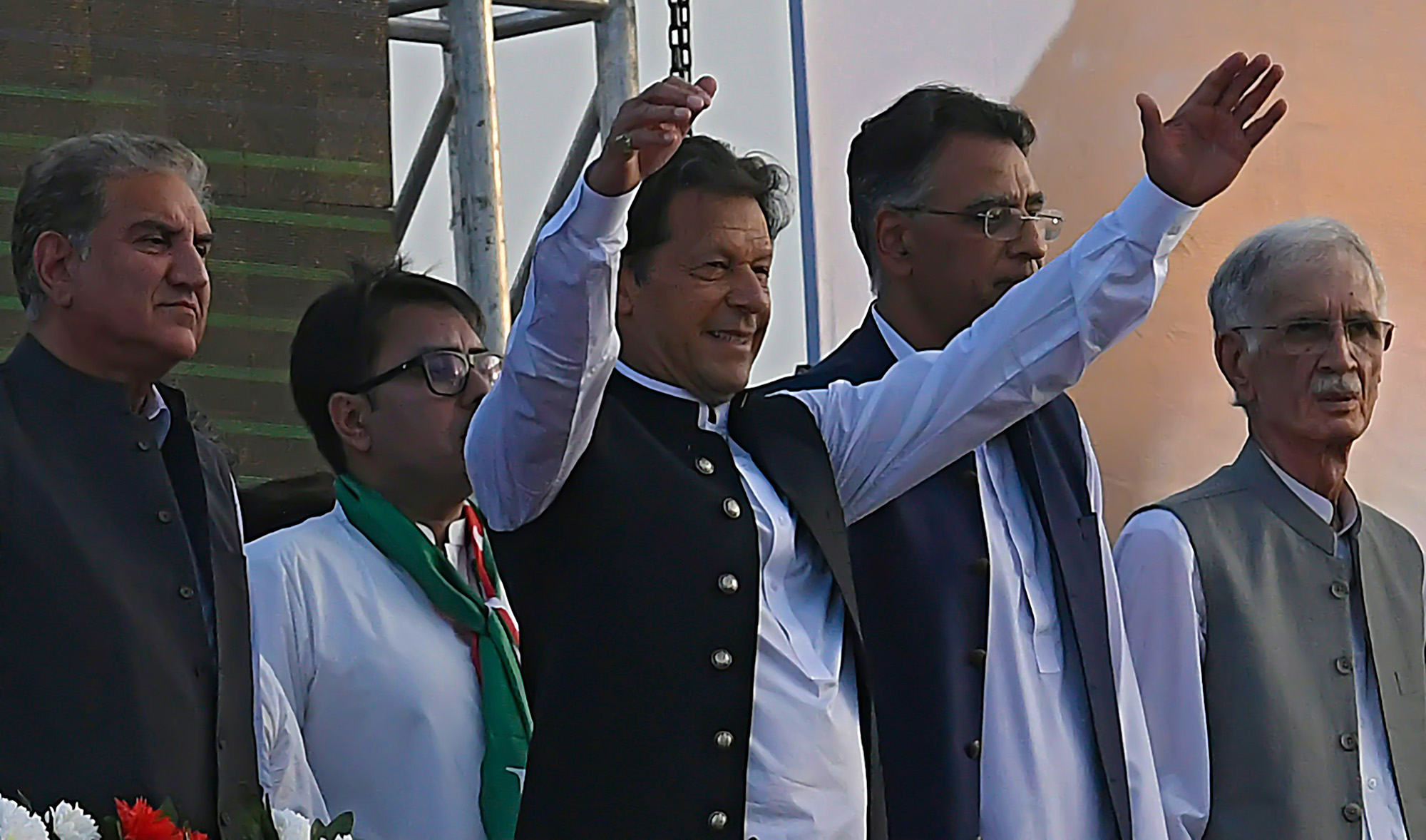 Pakistan's Prime Minister Imran Khan, center, along with other lawmakers, gestures upon his arrival to address the supporters of ruling Pakistan Tehreek-e-Insaf (PTI) party during a rally in Islamabad on March 27, 2022. (AFP)