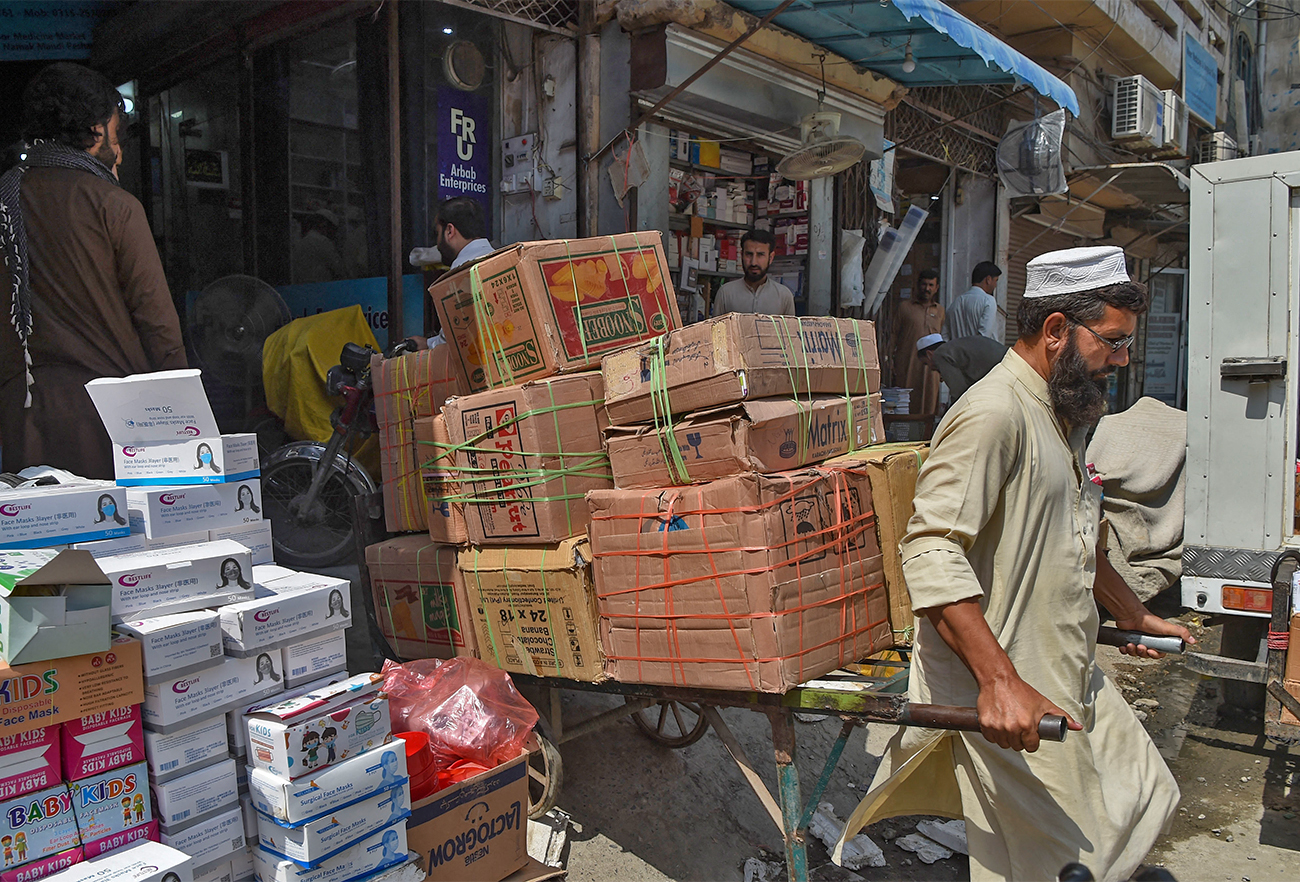 A labourer pulls a trolley loaded with medicine at a market in Peshawar, Pakistan, on September 1, 2021. (AFP/File)