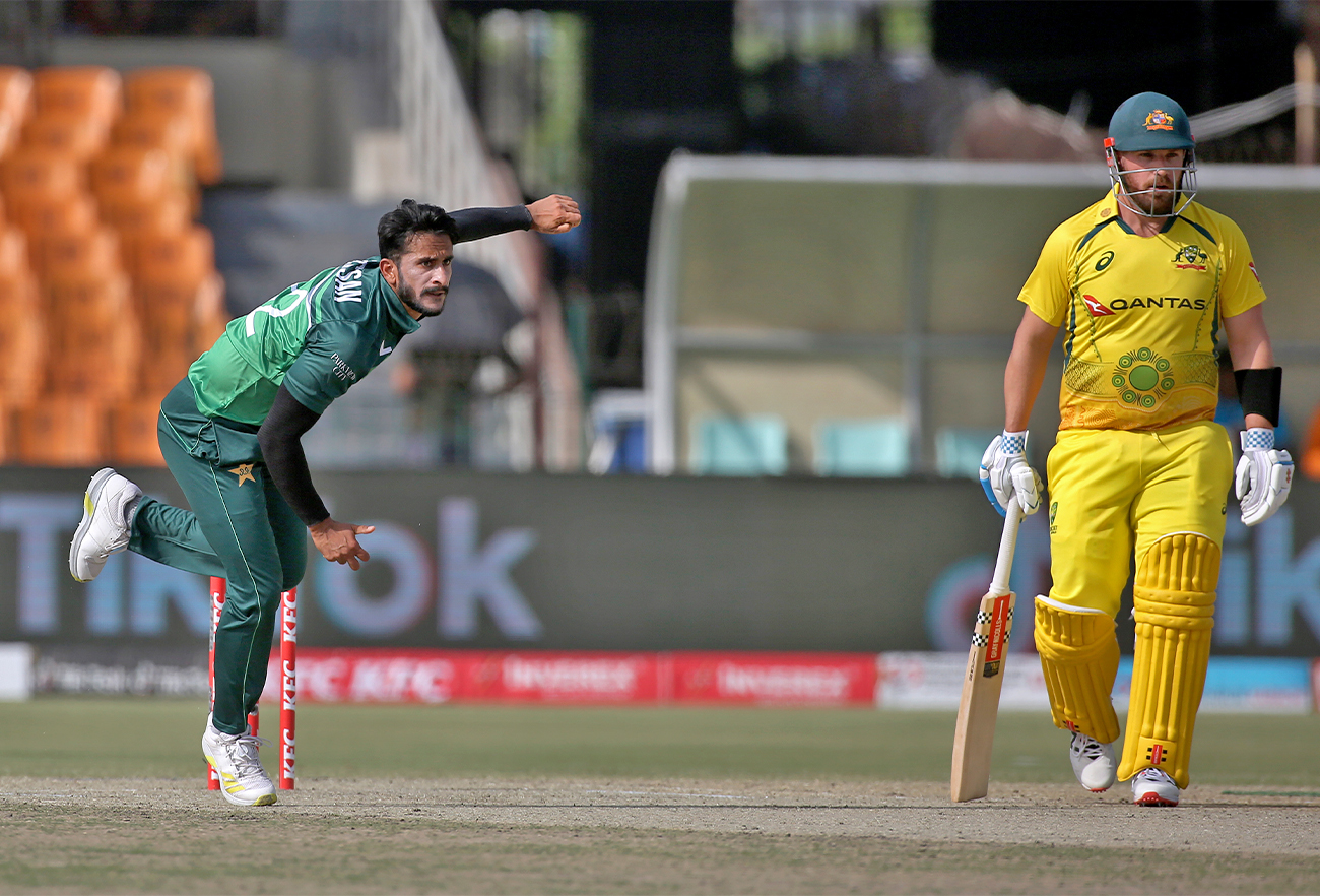 Pakistan's Hasan Ali, left, bowls while Australia's Aaron Finch watches during the first One Day International cricket match between Pakistan and Australia in Lahore, Pakistan, on March 29, 2022. (AP/File)