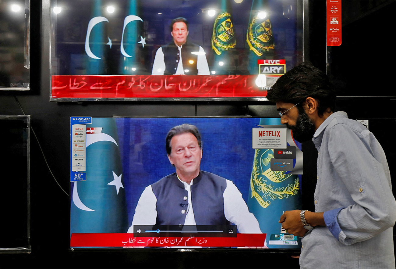 A shopkeeper tunes a television screen to watch the speech of Pakistani Prime Minister Imran Khan, at his shop in Islamabad, Pakistan, on March 31, 2022. (REUTERS)