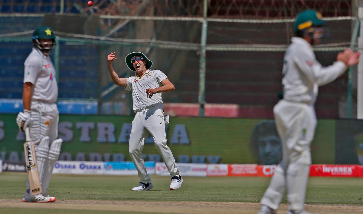 Australia's Pat Cummins, center, celebrates after taking the catch of Pakistan Imam-ul-Haq during the third day of the second test at the National Stadium in Karachi, Pakistan on March 14, 2022. (AP)