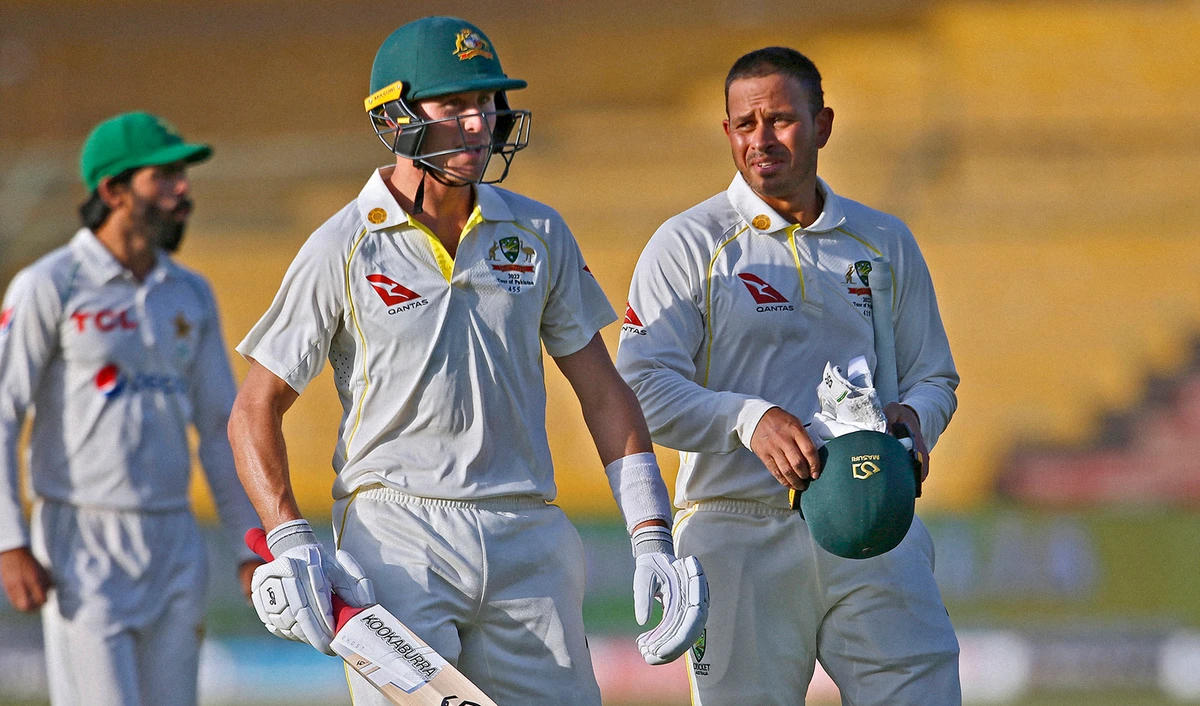 Australia's Usman Khawaja, right, and Marnus Labuschagne, center, walk back to pavilion at the end of the third day play of the second test against Pakistan at the National Stadium in Karachi, Pakistan, on March 14, 2022. (AP)