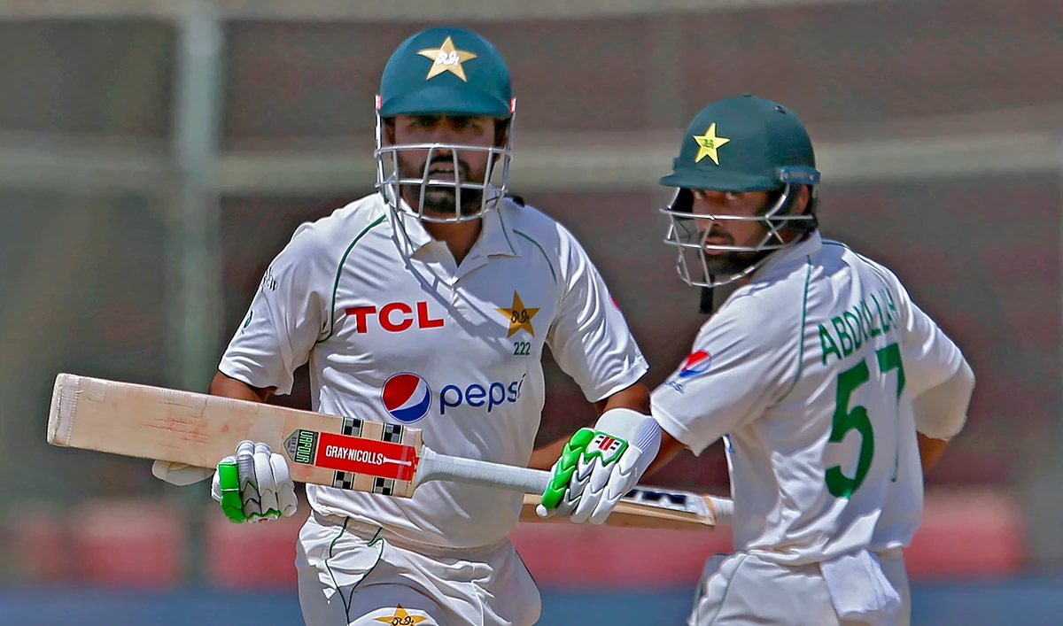 Pakistan's Babar Azam, left, and Abdullah Shafique run between the wickets during the fourth day of the second test match against Australia at the National Stadium in Karachi Pakistan, on March 15, 2022. (AP)