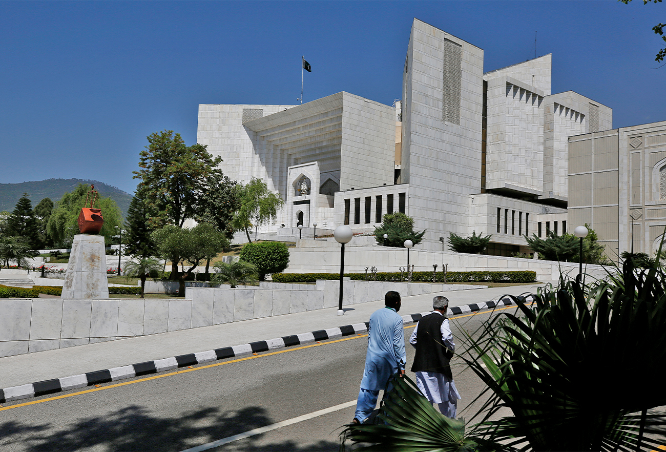 People walks past the Supreme Court where a petition hearing to dissolve parliament by country's Prime Minister is taking place in Islamabad, Pakistan, on April 4, 2022. (AP)
