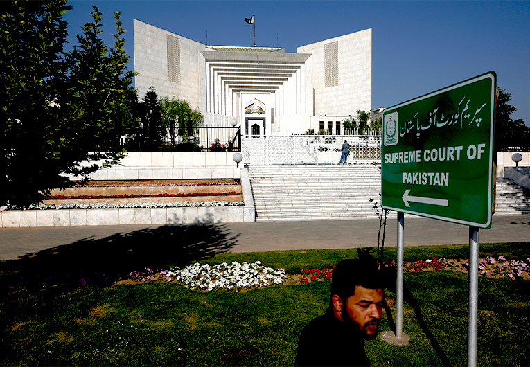 A man walks past the Supreme Court where petitions hearing to dissolve parliament by country's Prime Minister is held, in Islamabad, Pakistan, Monday, April 4, 2022. (AP)