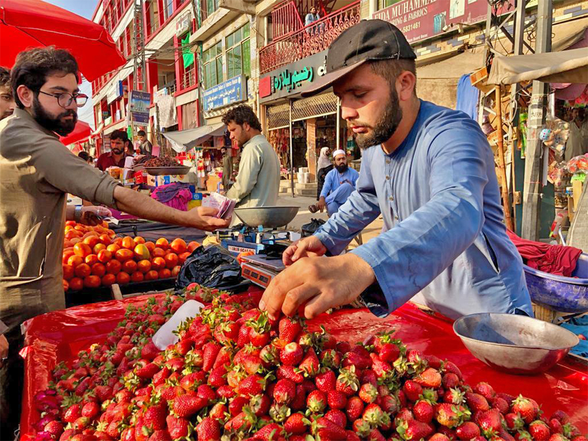An Afghan refugee sells strawberries before iftar at a roadside stall in Peshawar, Pakistan, on April 4, 2022. (AN photo)