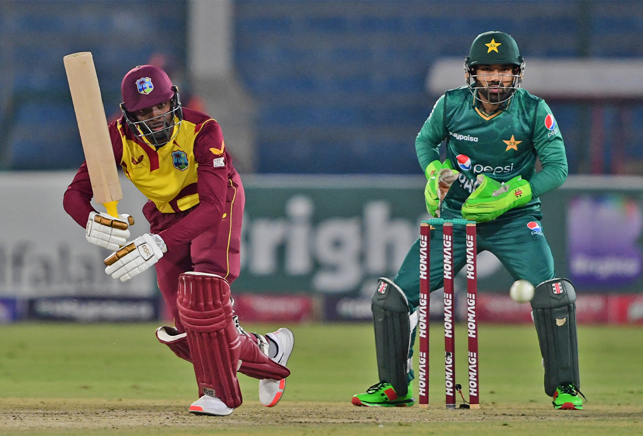 West Indies' Shamarh Brooks (L) plays a shot as Pakistan's wicketkeeper Mohammad Rizwan watches during a cricket match between Pakistan and West Indies in Karachi on December 13, 2021. (AFP/File)