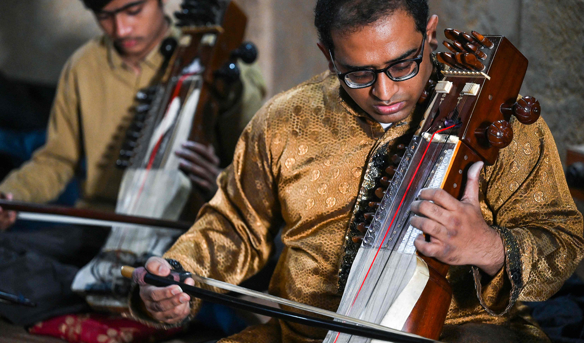 Zohaib Hassan, right, teaches his students to play sarangi at his academy in Lahore on February 24, 2022. (AFP/File)