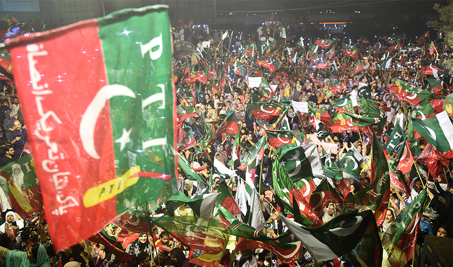 Supporters of Pakistan Tehreek-e-Insaf (PTI) party of dismissed Pakistan's prime minister Imran Khan, wave party flags as take part in a rally in his support in Karachi on April 10, 2022. (AFP)