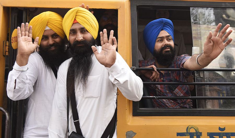 Sikh pilgrims wave from a bus before leaving to Pakistan for 'Baisakhi', a spring harvest festival for Sikhs and Hindus, in Amritsar on April 12, 2022. (AFP)