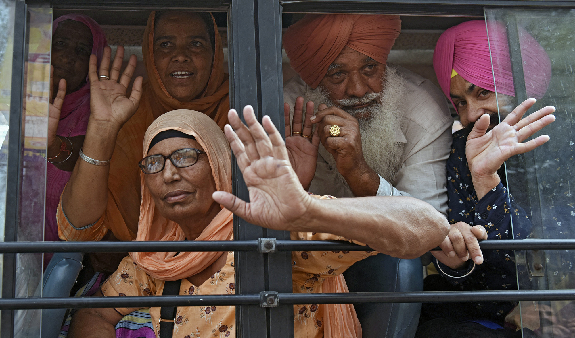 Sikh pilgrims wave from a bus before leaving to Pakistan for Vaisakhi, a spring harvest festival for Sikhs and Hindus, in Amritsar on April 12, 2022. (AFP)