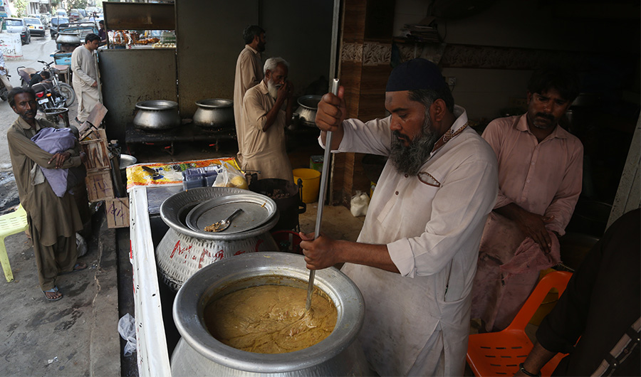 Muhammad Arshad, a chef, beats harees to blend meat with wheat and spices at Mumtaz Caterers in Karachi’s Hyderabad Colony on April 12, 2022. (AN Photo)