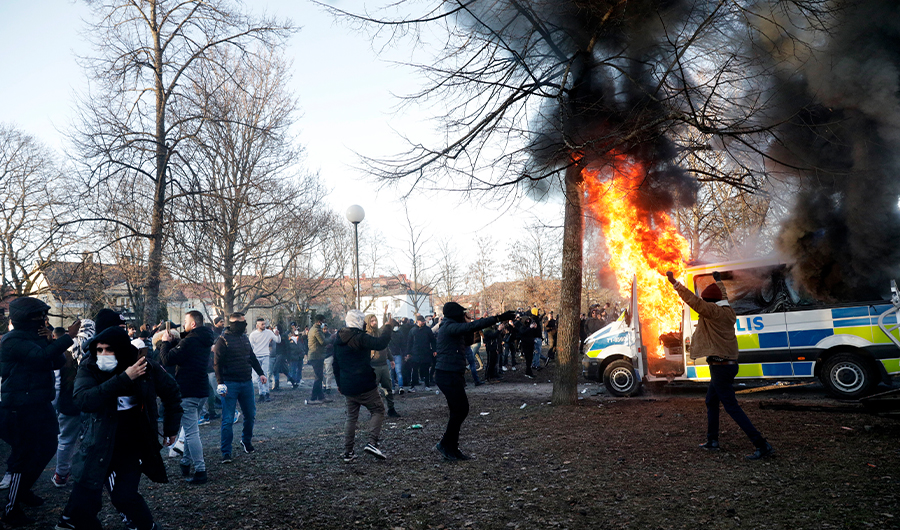 Police vans are on fire as counter-protesters react during a counter-protest in the park Sveaparken in Orebro, south-centre Sweden on April 15, 2022. (AFP)
