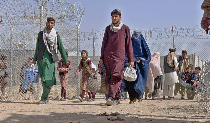 Afghans walk through a security barrier as they enter Pakistan through a border crossing point in Chaman, Pakistan, on August 26, 2021. (AP/FILE)