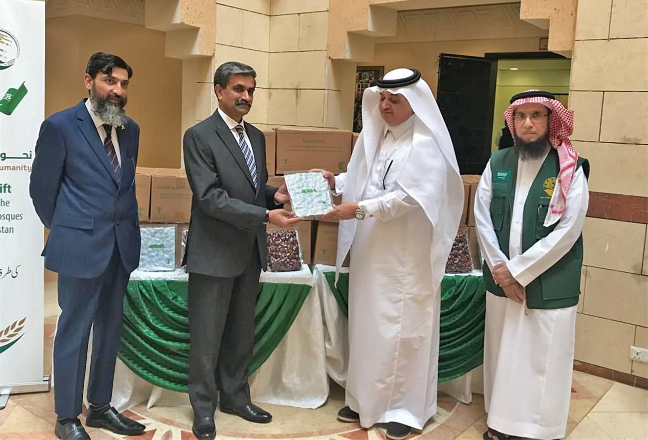 Saudi ambassador to Pakistan Nawaf bin Said Al-Malki (second from right) hands over 100 tons of dates to officials in Islamabad, Pakistan, on April 21, 2022. (AN Photo)