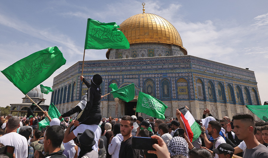 Palestinians wave national and Islamic flags inside Jerusalem's Al-Aqsa Mosque complex following prayers of the third Friday of the Muslim holy month of Ramadan, on April 22, 2022. (AFP)