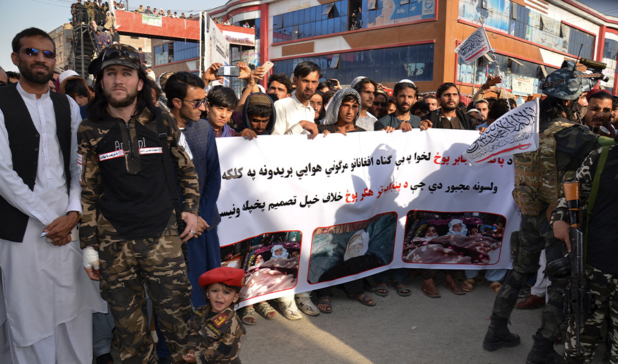 Demonstrators hold a banner during a protest against Pakistani airstrikes, in Khost on April 16, 2022. (AFP)
