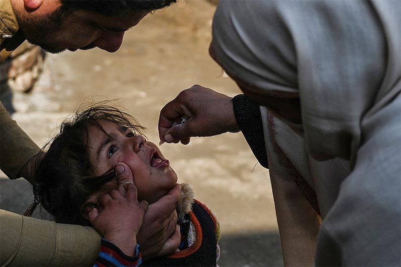 In this picture taken on January 24, 2022, a health worker administers polio vaccine drops to a child in Mardan, in Pakistan's Khyber Pakhtunkhwa province. (AFP/FILE)