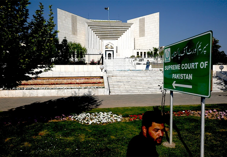 A man walks past the Supreme Court where petitions hearing to dissolve parliament by country's Prime Minister is held, in Islamabad, Pakistan, Monday, April 4, 2022. (AP)