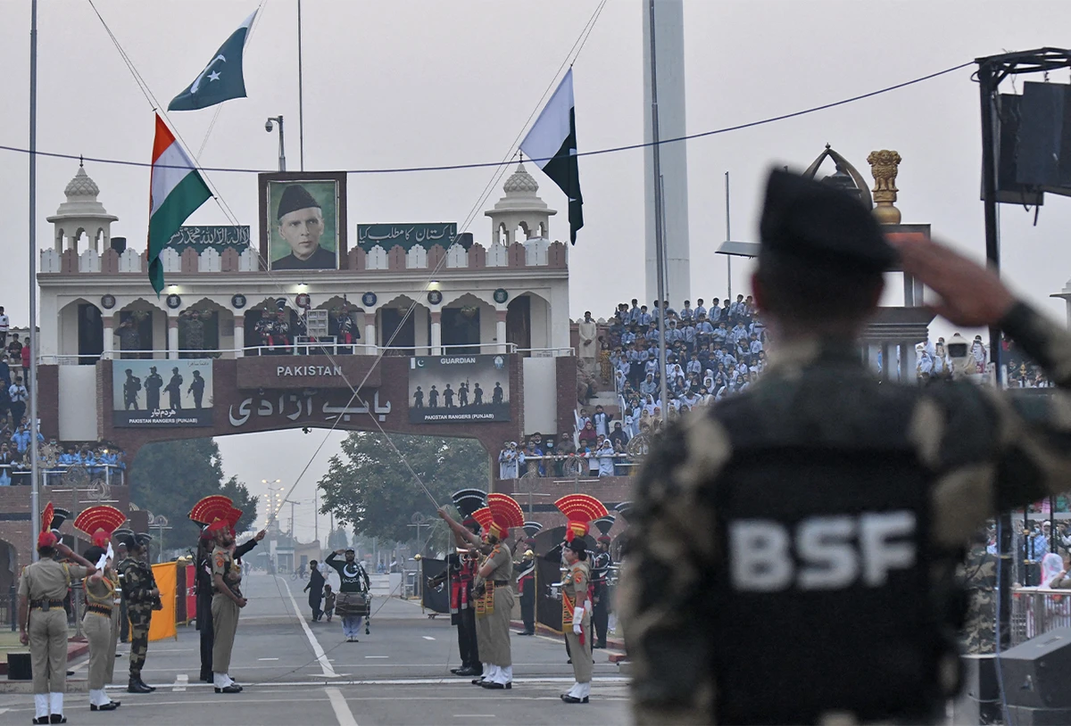 Indian Border Security Force (BSF) personnel and Pakistani Rangers (in black) lower their respective flags during the daily beating of the retreat ceremony at the India-Pakistan Wagah Border Post, about 35 km from Amritsar on November 15, 2021. (AFP)