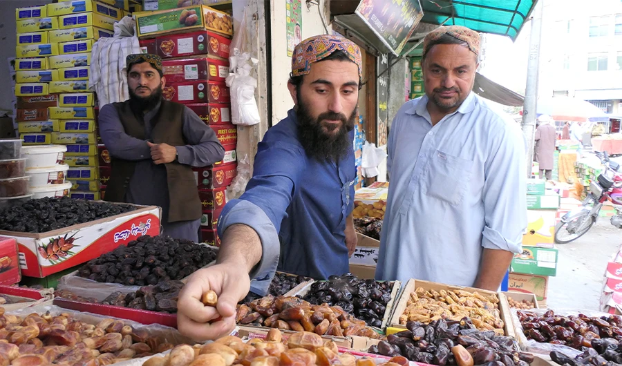 A local vendor at a date market shows different varieties of the fruit to customers at his shop in Quetta, Pakistan, on April 10, 2022. (AN Photo)