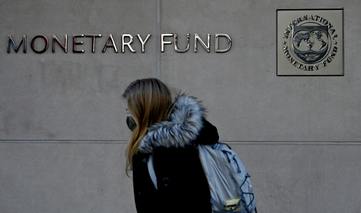 A woman walks past the International Monetary Fund headquarters in Washington, DC, on January 26, 2022. (AFP/File)