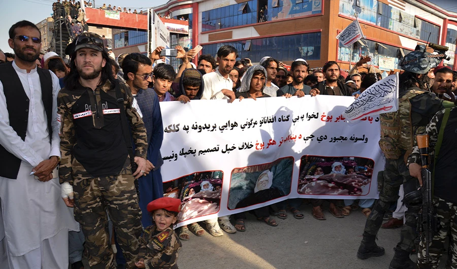 Demonstrators hold a banner during a protest against Pakistani airstrikes, in Khost on April 16, 2022. (AFP)