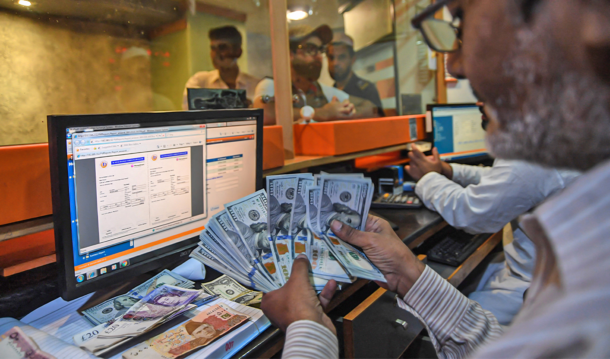 A Pakistani currency dealer counts US dollars at a currency exchange shop in Karachi, Pakistan, on August 1, 2018. (AFP/File)