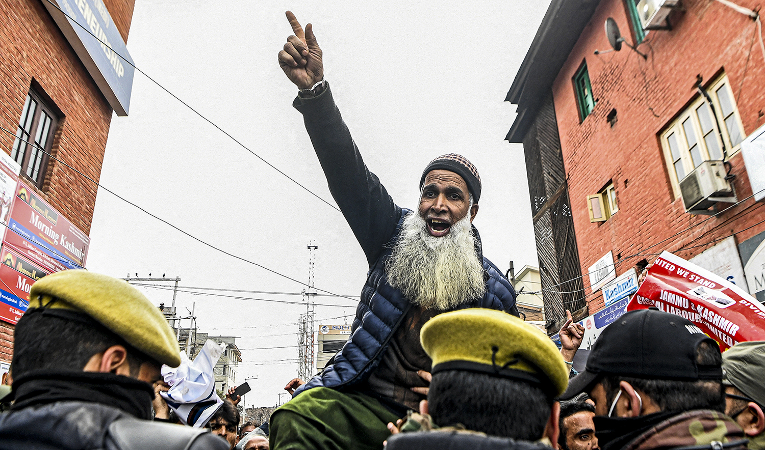 Laborers chant slogans while police try to stop them as they protest to demand the regularizations of their jobs in Srinagar on March 2, 2022. (AFP/File)