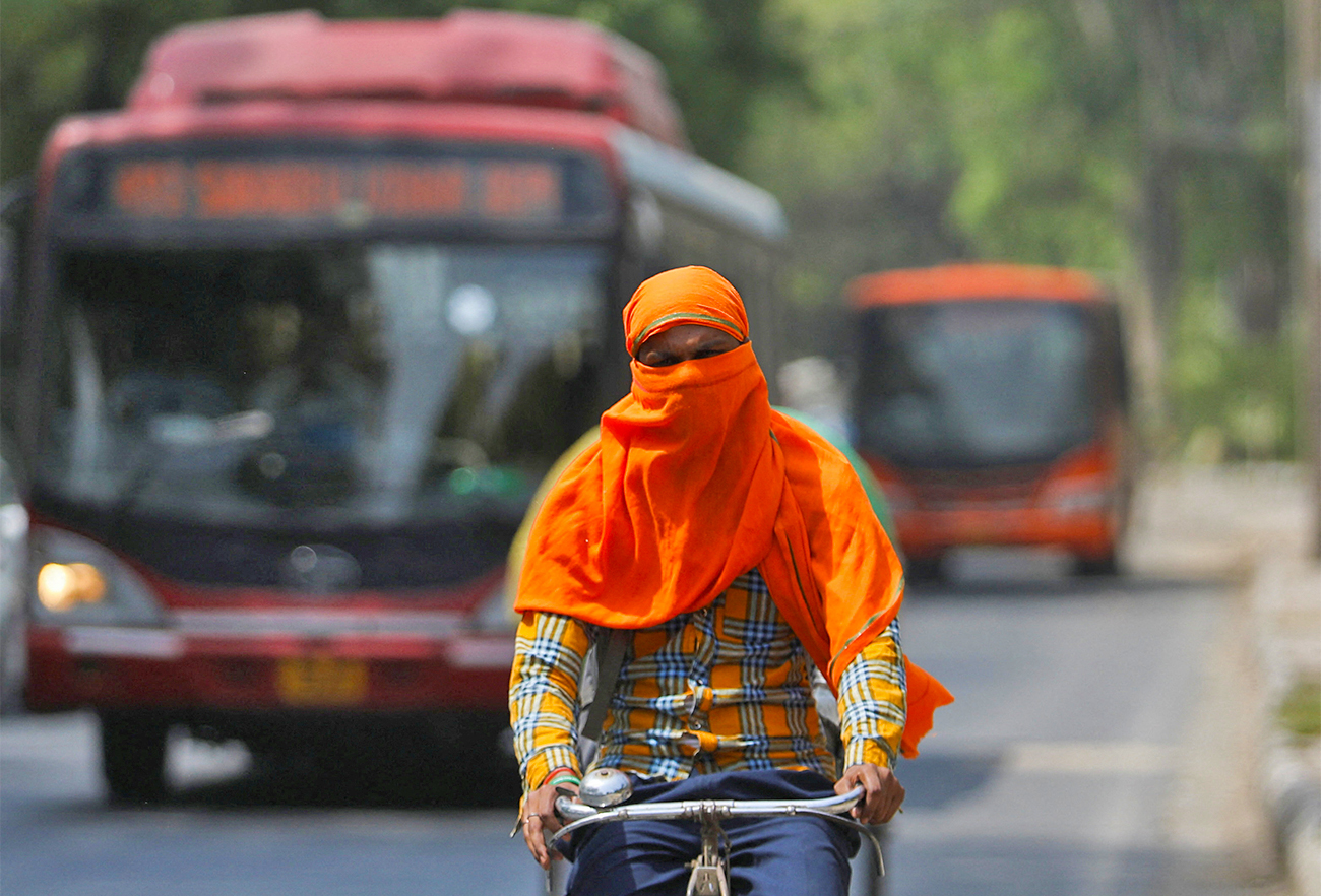 A man rides a cycle with his face fully covered, on a hot summer day, in New Delhi, India, on April 26, 2022. (REUTERS)