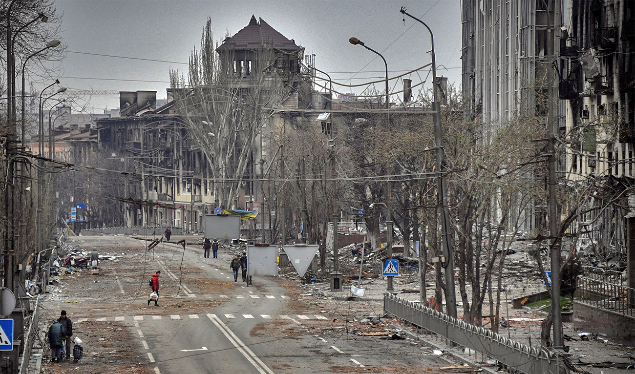 People walk down an avenue of Mariupol, Ukraine, on April 12, 2022, as Russian troops intensify a campaign to take the strategic port city. (AFP)