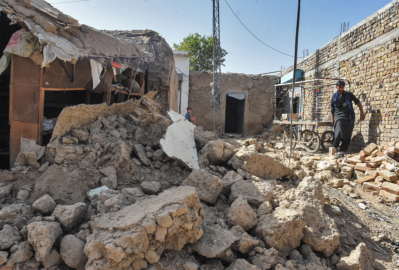 A resident removes a cart beside the rubble of collapsed houses following an earthquake in the remote mountainous district of Harnai, Balochistan, on October 7, 2021. (AFP/File)