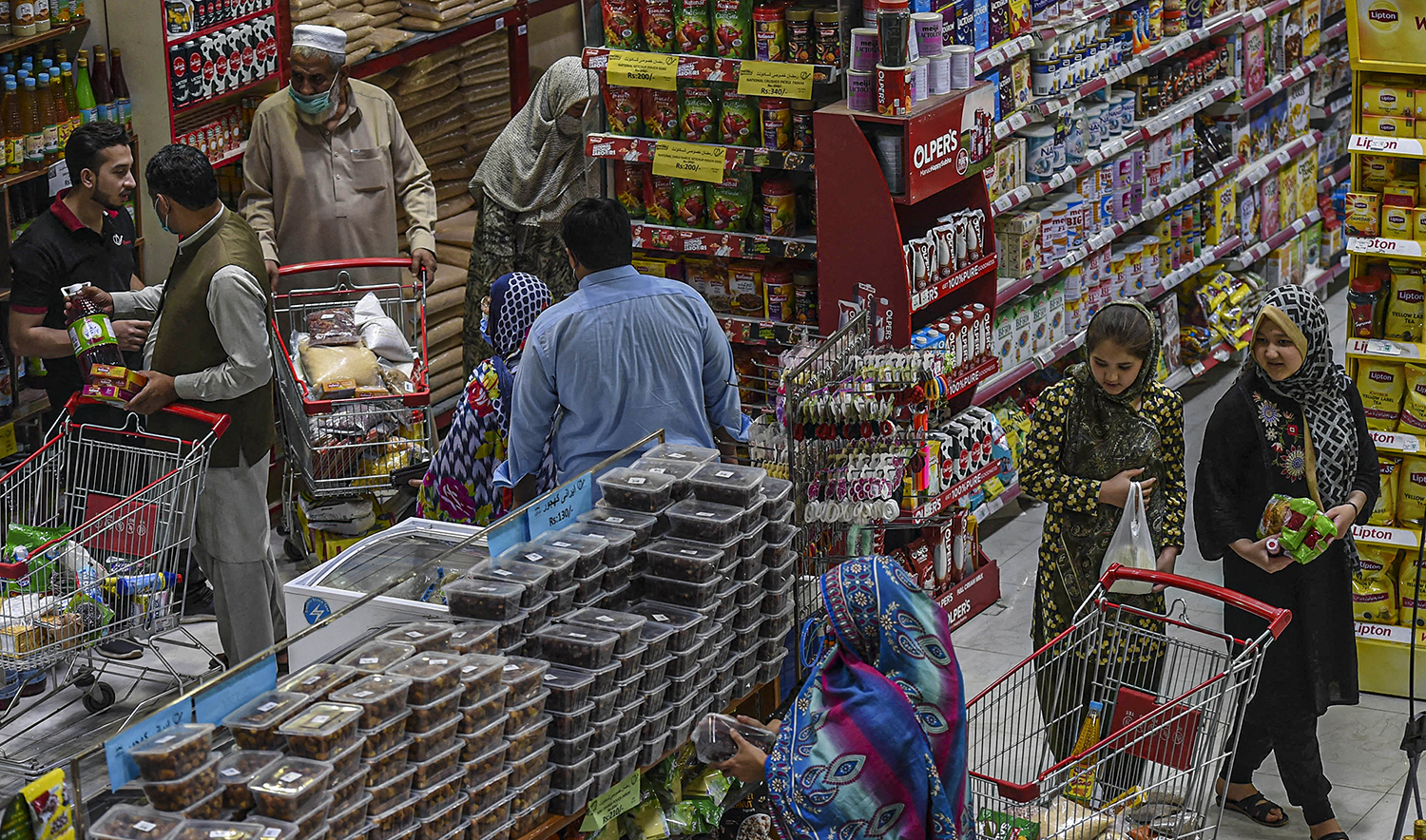 People buy grocery items at a store in Peshawar, Pakistan, on April 5, 2021. (AFP/File)