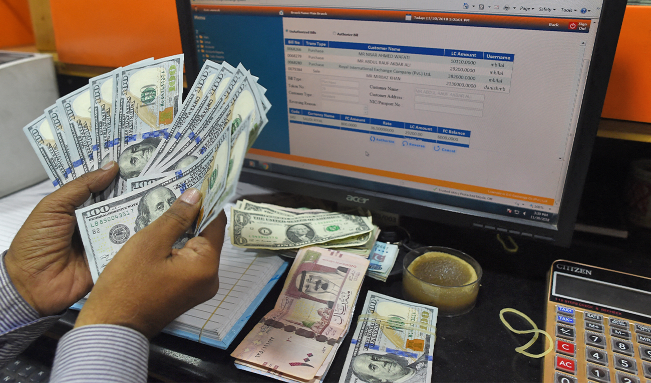 A Pakistani dealer counts US dollars at a currency exchange shop in Karachi, Pakistan, on November 30, 2018. (AFP/File)