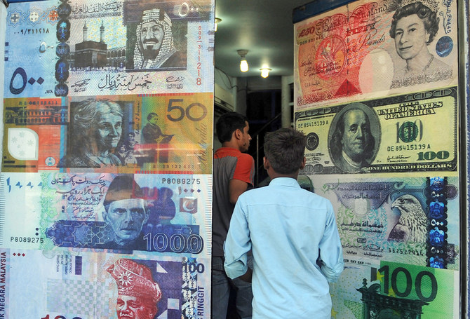 Pakistani customers enter a foreign currency exchange shop in Karachi, Pakistan, on October 14, 2010. (AFP/File)