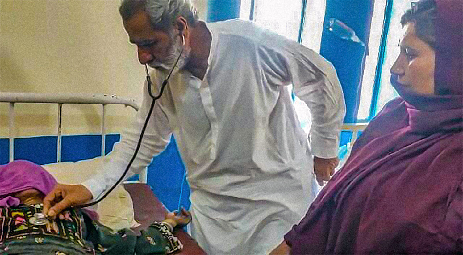 A doctor examines a woman diagnosed with cholera in Pir Koh, a settlement in the remote region of Dera Bugti in Pakistan’s Balochistan province on May 11, 2022. (Photo courtesy: Wadera Qadir Bugti)