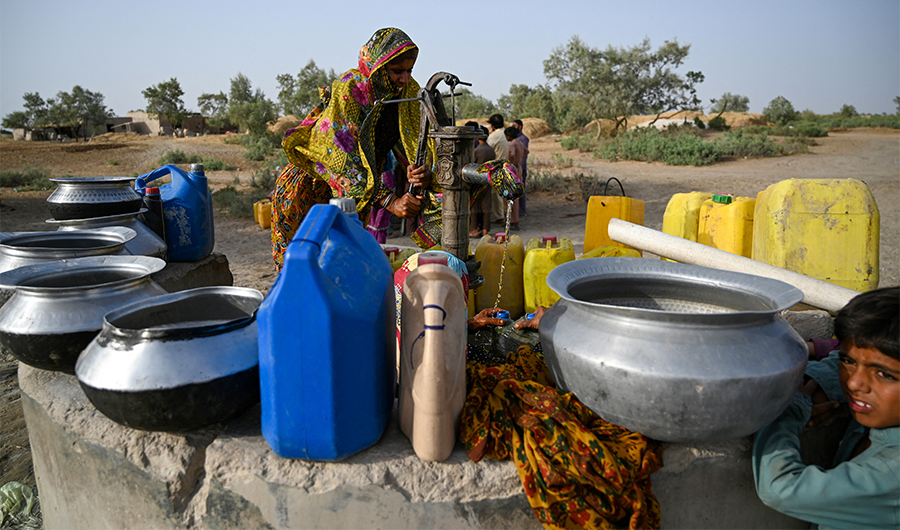 In this picture taken on May 11, 2022, a woman fills cans with water from a hand pump during a heatwave in Jacobabad, in the southern Sindh province. (AFP)