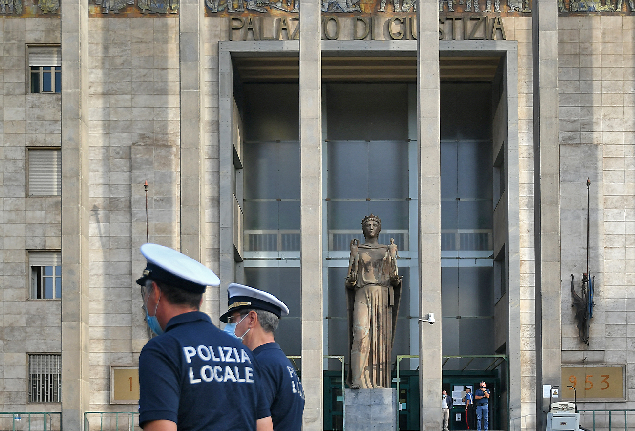 Local Police officers walk past the courthouse of Catania, Italy, on October 3, 2020. (AFP/File)