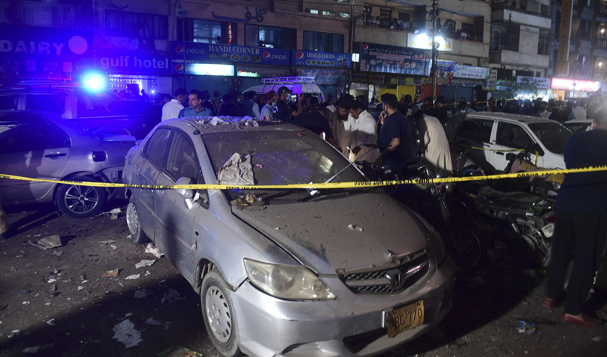 Security officials inspect the site after the explosion of a bomb, in Karachi, Pakistan on May 12, 2022. (AFP/File)