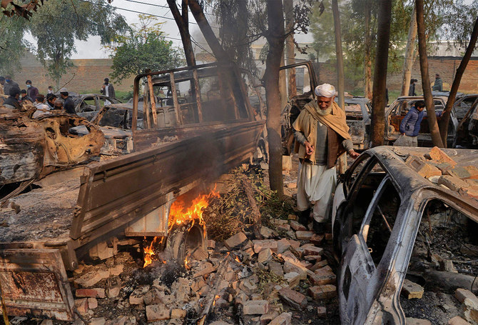 Car on fire is pictured as demonstrators gather at a police station that was set on fire, in Charsadda, Pakistan, on November 29, 2021. (AFP/FILR)