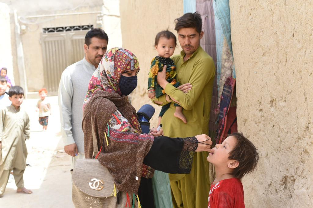 A polio health worker administers polio vaccine to a kid in Quetta, Pakistan on May 23, 2022. (Emergency Operation Center)