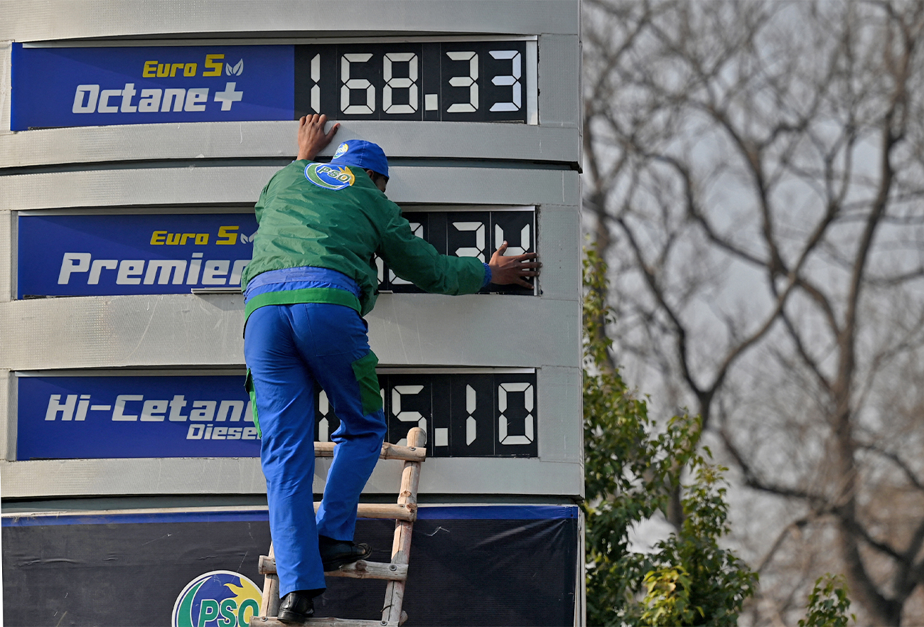 An employee of a fuel station updates the latest fuel price list in Islamabad, Pakistan, on February 16, 2022. (AFP)