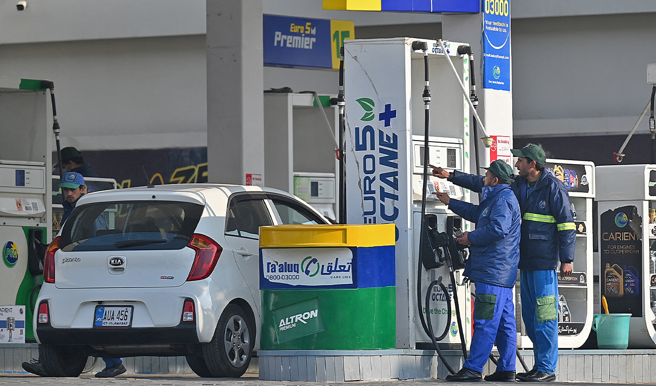 Employees at a fuel station attend to their customers in Islamabad, Pakistan, on February 16, 2022. (AFP/File)