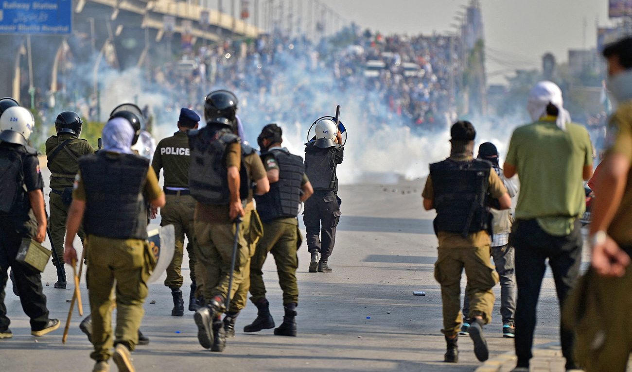 Policemen fire tear gas shells towards supporters of Pakistan's former prime minister Imran Khan during a protest rally in Rawalpindi, Pakistan, on May 25, 2022. (AFP)